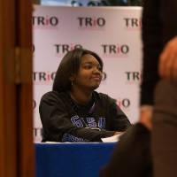 Image of student worker seated at sign in table